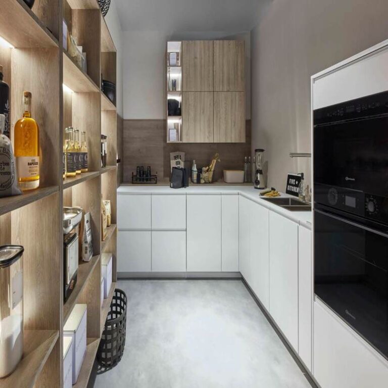Moderne weiße Küche Moderne weiße Küche mit Hochschränken, Holzregal und schwarzen Einbaugeräten – Küchenberatung Braunschweig