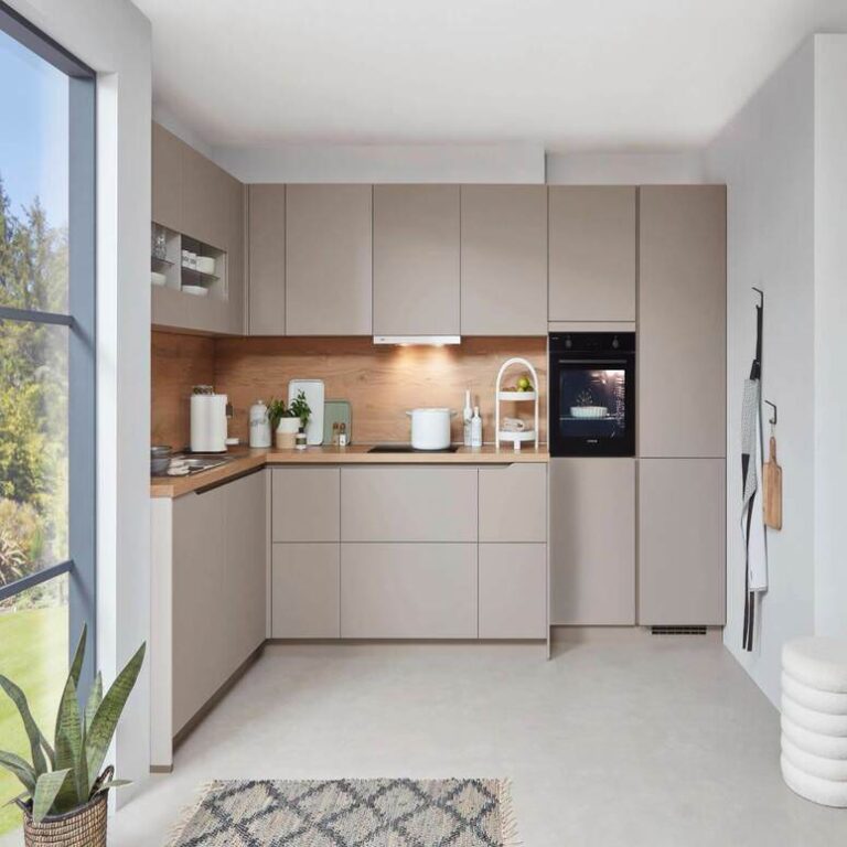 Musterküche in Kaschmir Musterküche in Kaschmir als L-Küche mit Holzrückwand und Backofen im Hochschrank – Persönliche Küchenberatung